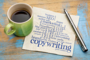Copywriting written on a napkin with a cup of coffee and a pen